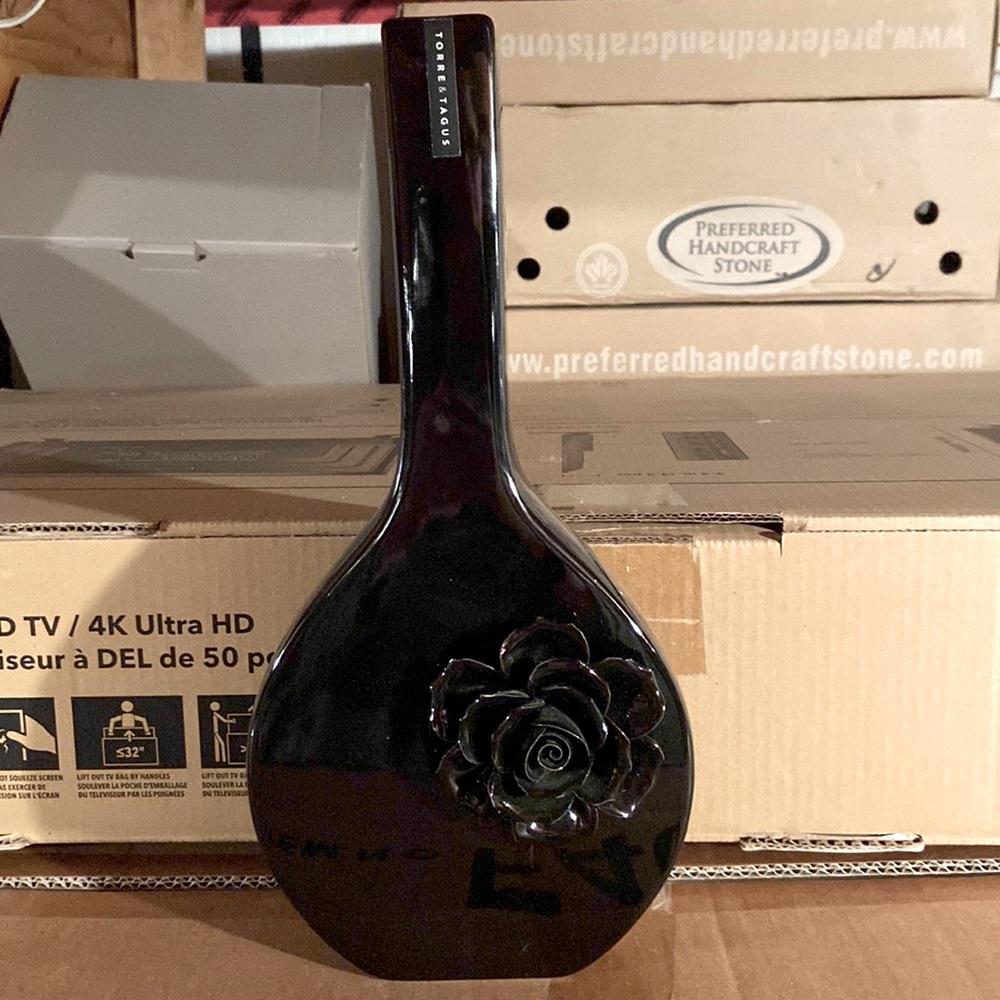 Beautiful sleek black tall black vase with flower accent on the front